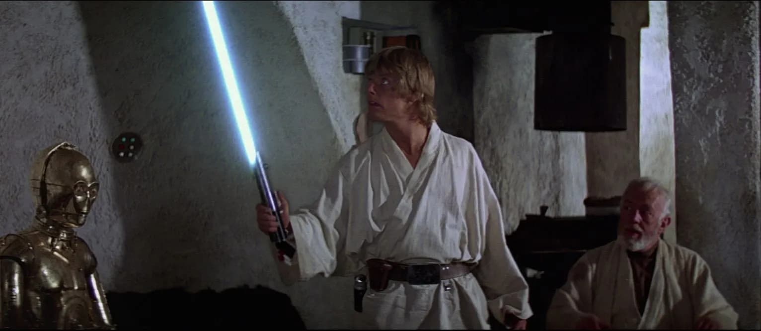 Luke découvre le sabre laser de son père sous le regard d'Obi-Wan Kenobi